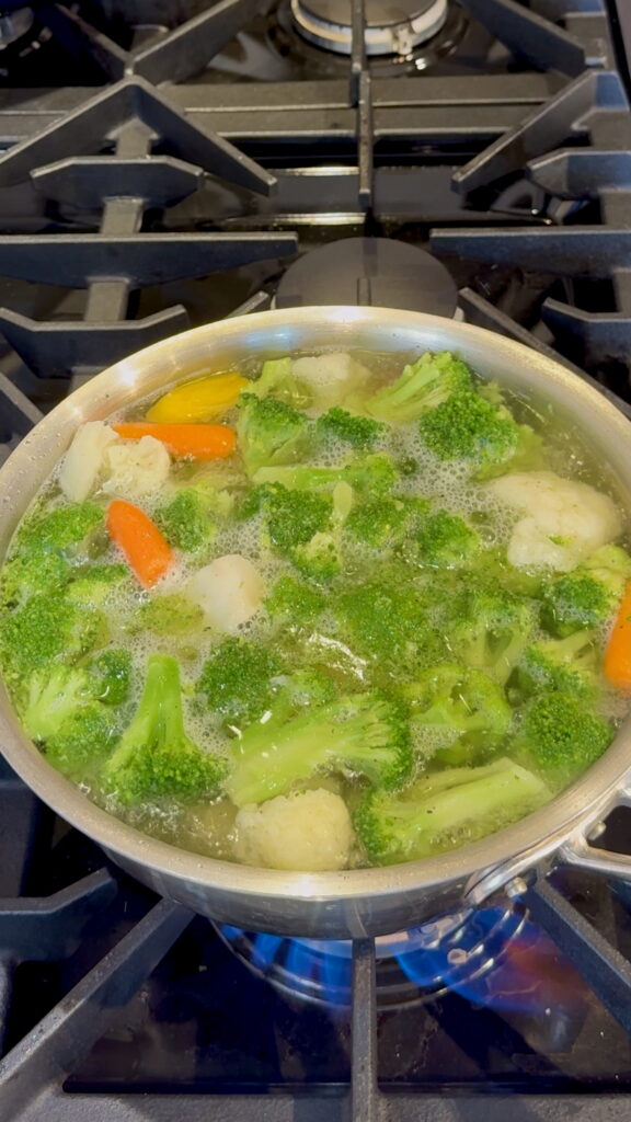 Pot on stove with veggies boiling.