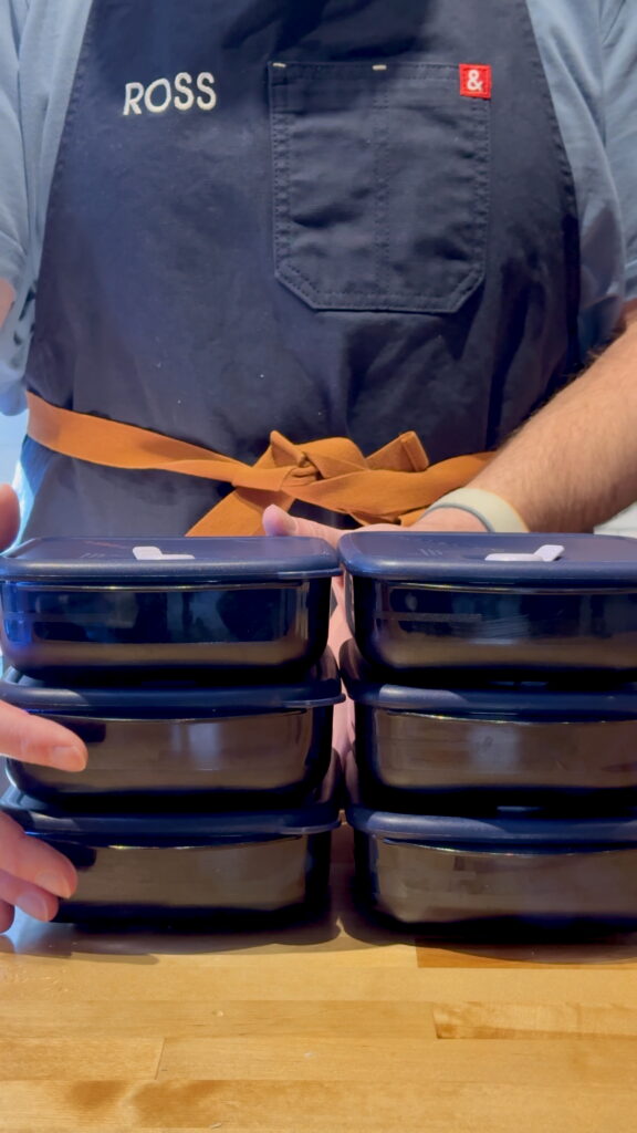 Ross grabbing three of the meal prep containers stacked three containers high