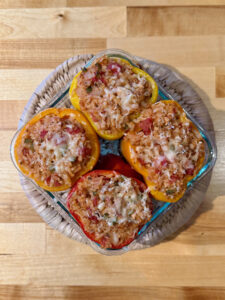 Four roasted stuffed peppers in a diamond formation on a trivot