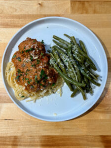 Spaghetti with Meatballs, Meat Sauce, and Sautéd Green Beans on a white plate