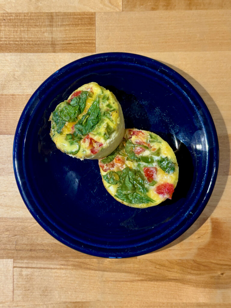 Two vegetable egg bites on a blue plate